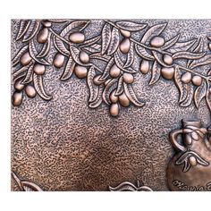 an image of a metal plate with fruit and leaves on it, as well as a vase