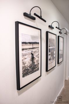 three black and white pictures hang on the wall next to each other in a hallway