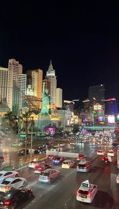 a busy city street filled with lots of traffic and tall buildings lit up at night