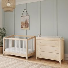 a baby's room with a dresser and crib next to it in front of a painting