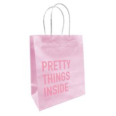 a pink shopping bag with the words pretty things inside printed on it, against a white background