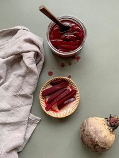 beets are sitting on a table next to a bowl of pickled up beets