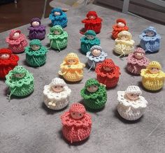 small crocheted dolls sitting on top of a gray table next to each other