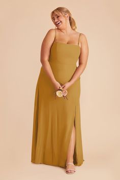 a woman in a tan dress is smiling