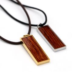 Hawaiian Koa Wood Rectangle Pendant Experience the beauty and uniqueness of Hawaiian culture with this Koa wood pendant. Handcrafted from Koa wood, each piece features a one-of-a-kind wood grain framed in three stylish colors, silver-plated, gold-plated, or rose gold-plated steel bezel. The leather cord necklace adds a touch of modernity to this Hawaii treasure inspired by the strength and bravery of Polynesian warriors. Embrace the rich traditions of Hawaiian wooden jewelry with this elegant an Wood Necklace Pendant, Wood And Resin Jewelry, Ranch Logo, Leather Cord Necklace, Hawaiian Culture, Rectangle Pendant, Koa Wood, Leather Corded Necklace, Wooden Necklace