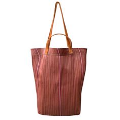 Each tote bag is meticulously stitched by artisans in Assam, India, under fair trade conditions, then finished with leather straps and detailing in Brooklyn, New York. Perfect for the market, beach, or everyday use, our tote bags not only support the livelihoods of our artisan partners but also help keep plastic out of landfills. perfect for a couple of bottles of wine and a baguette! H: 17" W: 16" Recycled Plastic and Leather. Handwoven Leather Tote Beach Bag, Market Tote Shoulder Bag With Leather Handles, Ethically Sourced Brown Beach Bags, Eco-friendly Beach Bag With Leather Handles For Everyday Use, Tote Shoulder Bag With Leather Handles For Market, Leather Handle Tote Shoulder Bag For Market, Artisan Tote Beach Bag For Everyday Use, Rectangular Bucket Bag With Leather Handles For Market, Daily Use Fair Trade Tote Shoulder Bag