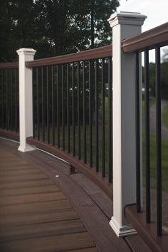 a wooden deck with white posts and black railing