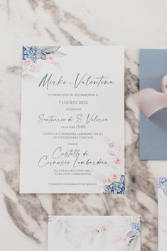 the wedding stationery is laid out on a marble surface