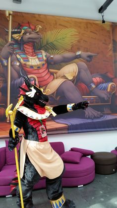 a statue of a man dressed as an egyptian soldier in front of a large painting