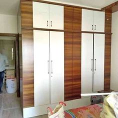 a man is standing in the kitchen next to some cupboards