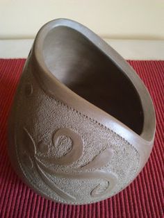 a brown vase sitting on top of a red mat