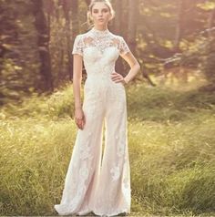 a woman standing in the grass wearing a white dress