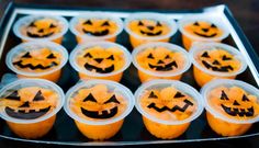 cupcakes decorated with jack - o'- lantern faces in plastic cups