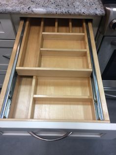 an open drawer in the middle of a kitchen