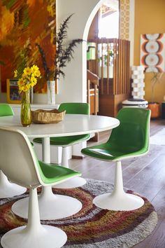 a white table with green chairs around it