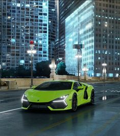 a bright green sports car parked in the middle of a city street at night with tall buildings behind it