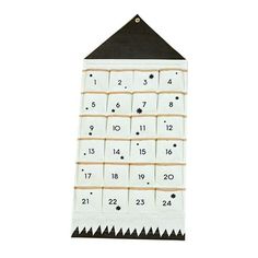 a white and black calendar hanging on a wall with numbers attached to the front of it