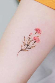 a small flower tattoo on the right side of the leg, with pink flowers in it