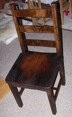 a wooden chair sitting on top of a carpeted floor