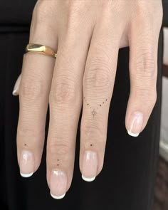 a woman's gold ring with tiny stars on her left hand and two fingers