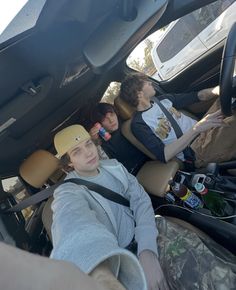 three people sitting in the back seat of a car