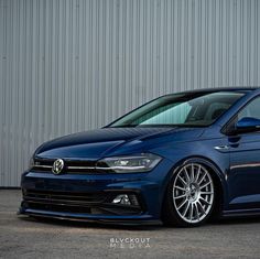 a blue volkswagen car parked in front of a building