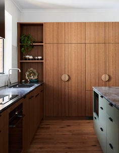 a kitchen with wooden cabinets and marble counter tops