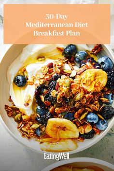 a bowl filled with yogurt, bananas and blueberries