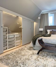 a bedroom with a bed, dressers and storage cabinets in it's corner