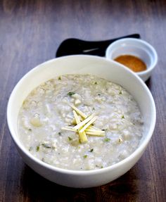 a white bowl filled with oatmeal sitting on top of a wooden table