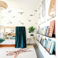 a bed room with a neatly made bed and lots of books on the shelves next to it