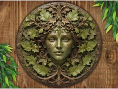 a green woman's face surrounded by leaves on a wooden background with greenery