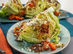 lettuce and tomato salad on two plates with utensils next to them