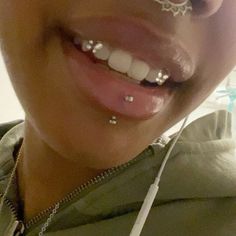 a woman with some piercings on her tongue and nose is smiling at the camera