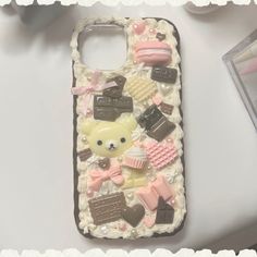 a cell phone case that has various items on it, including a teddy bear and other things