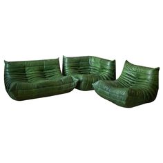 three pieces of green leather sitting next to each other