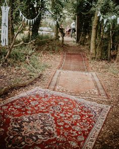 an old rug is laying on the ground in front of some trees and bunting