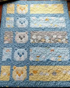 a blue and yellow quilt with teddy bears on it