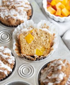 several muffins with frosting and peaches in the middle are ready to be eaten