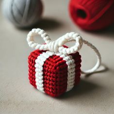 two balls of yarn are sitting next to each other on the table, one is red and white