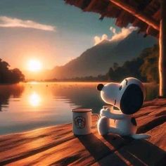 a cartoon dog sitting next to a coffee cup on a wooden dock with the sun setting in the background