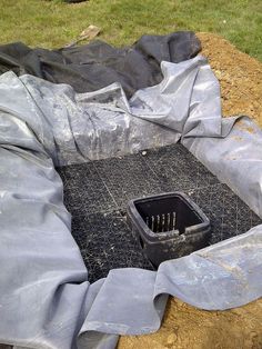 there is a plastic tarp over the hole in the ground that has tools inside