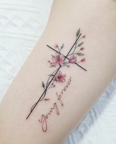 a woman's arm with flowers on it and the word love written in cursive writing