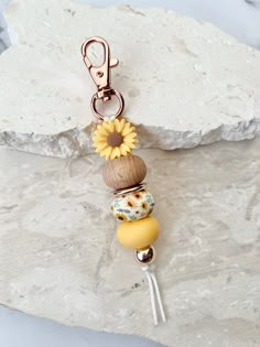 a keychain that has some beads on it and a flower attached to it