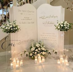 a table topped with lots of white flowers and candles