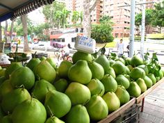 there are many green fruits on display at the market