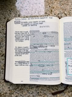 an open book with writing on it sitting on top of a granite counter next to a knife