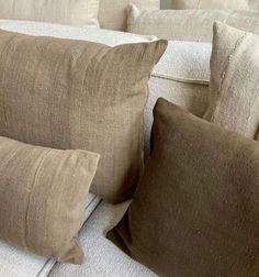 the pillows on the couch are made from linens that have been dyed brown and white