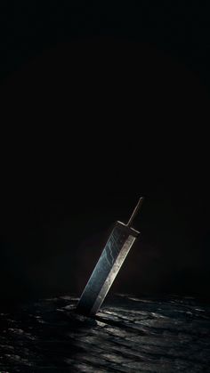 a large knife sticking out of the water in the middle of the ocean at night