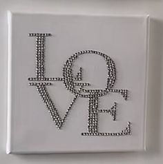 a white tile with the word love spelled in black letters on it's side